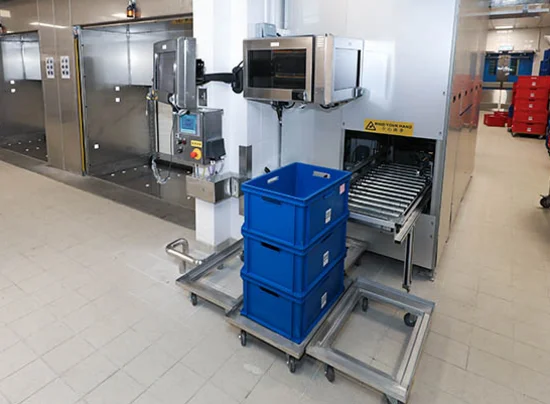Front view of a bin station connected to the conveyor system in a catering logistics facility