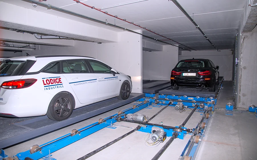 A white car is seen parked inside an automated parking system.